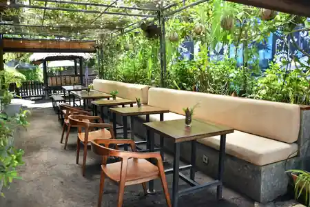 Lush tropical garden seating area with banquettes at Beach Garden in Bali — salsa, bachata venue in Bali