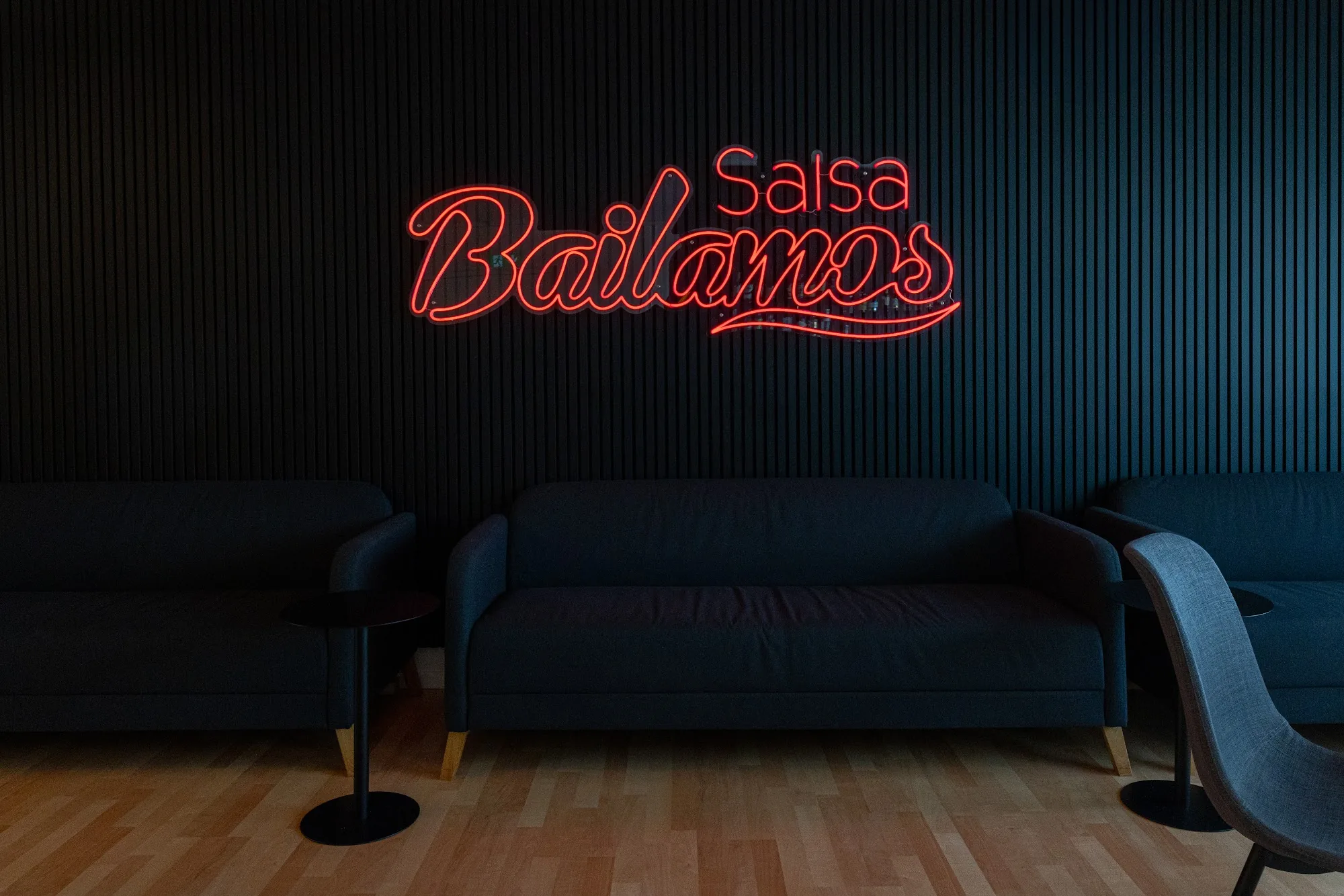Neon Bailamos Salsa sign with seating area at Bailamos Salsa studio, Basel