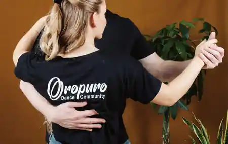 Partner dance hold showing the Oropuro Dance Community branded shirt in Amsterdam — salsa venue in Amsterdam