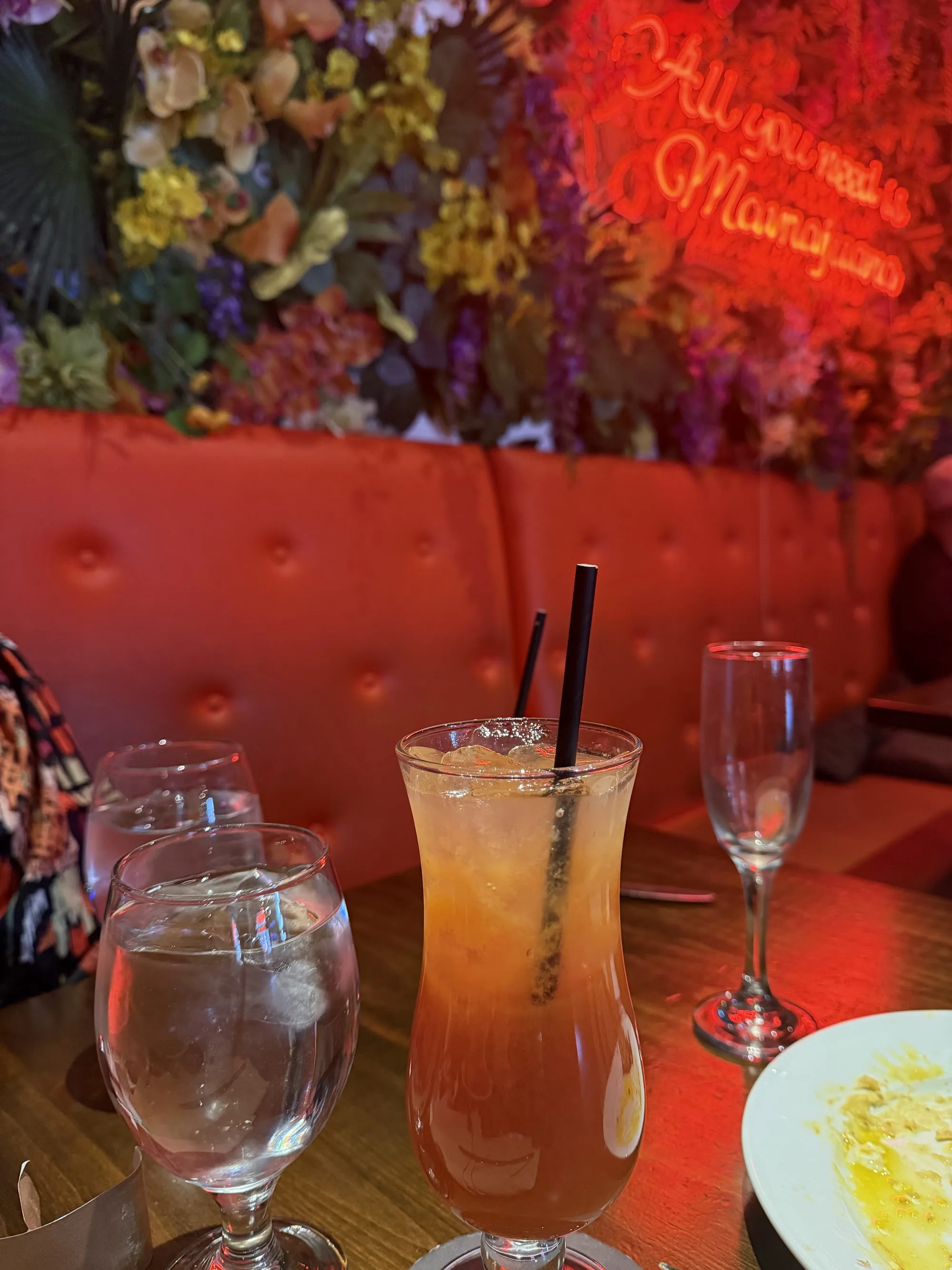 Mamajuana Cafe lounge atmosphere in New York with floral wall and neon Mamajuana sign