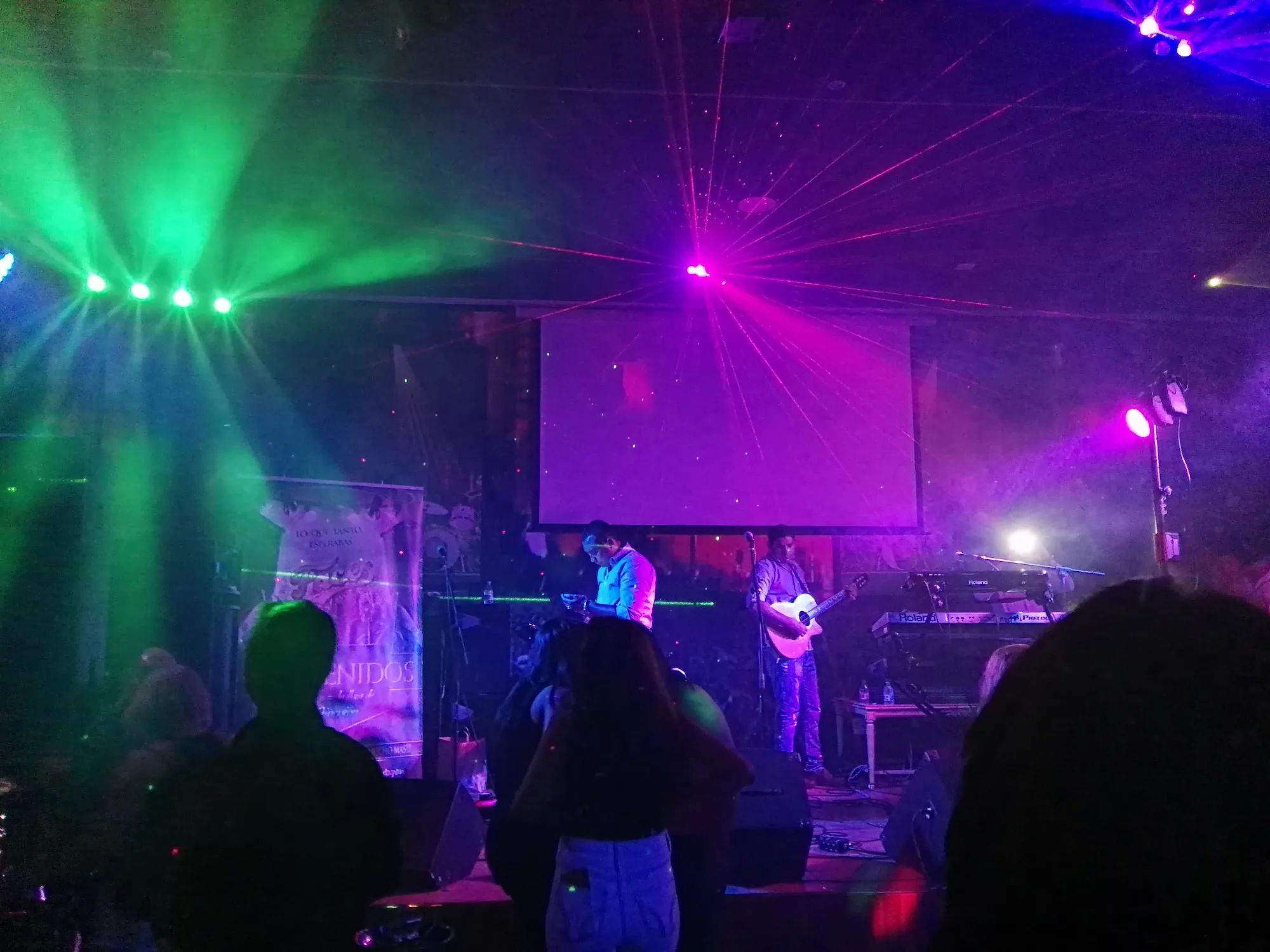 Live band on stage with laser lights and crowd at Sala La Farándula Málaga