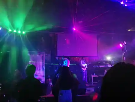 Live band on stage with laser lights and crowd at Sala La Farándula Málaga — salsa, bachata, kizomba venue in Málaga