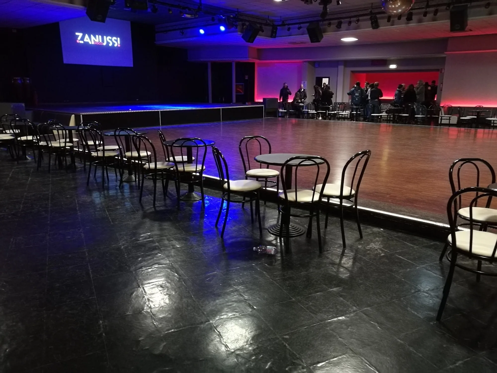 Dance floor with chairs arranged around it and stage at Zanussi Rome event space