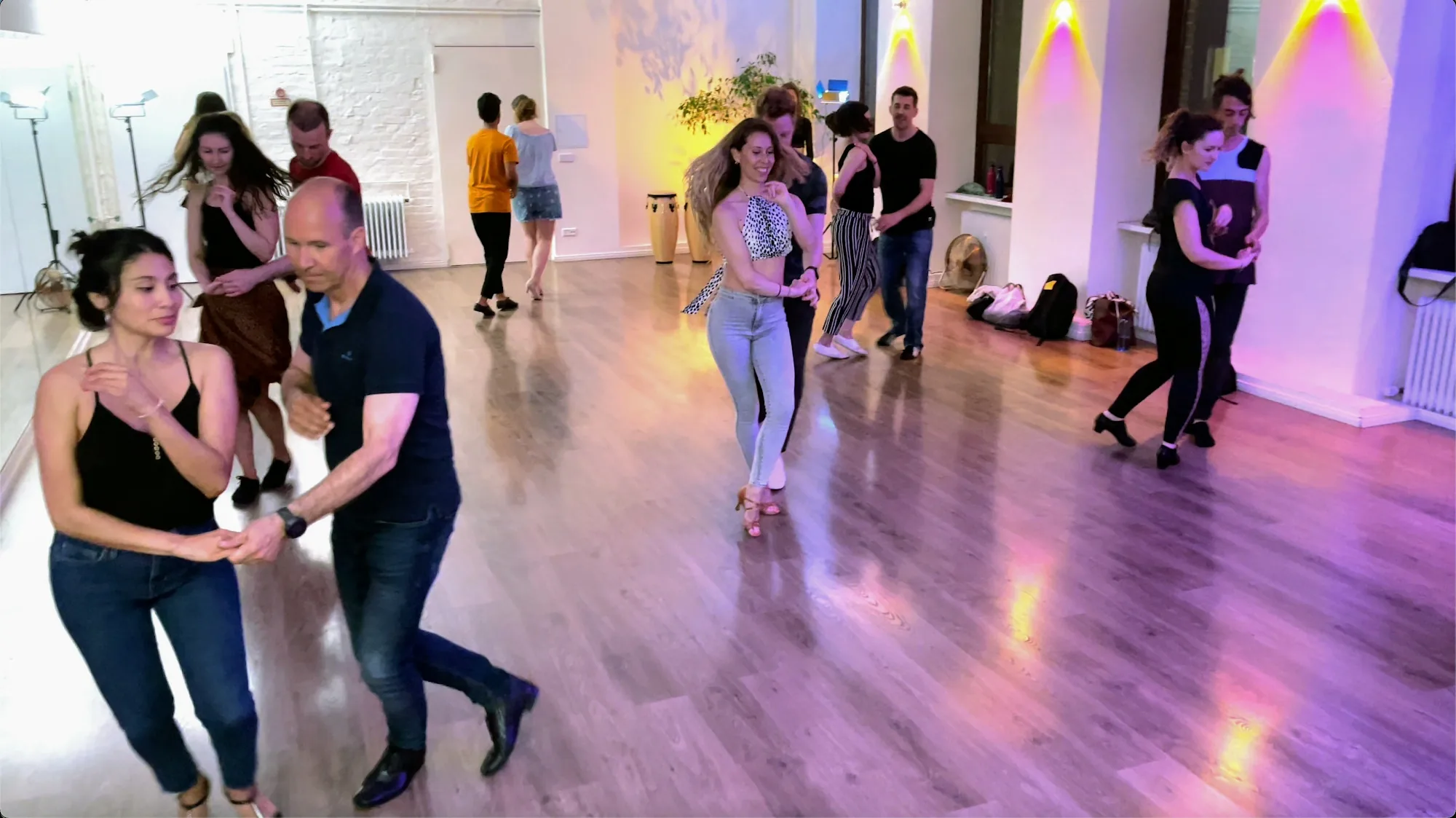 Salsa social dancers in partner hold on the wooden floor at Dolce Vita Dance Studio Berlin