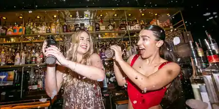 Bartenders shaking cocktails behind the bar at Be At One Liverpool Street London — salsa, bachata, kizomba venue in London