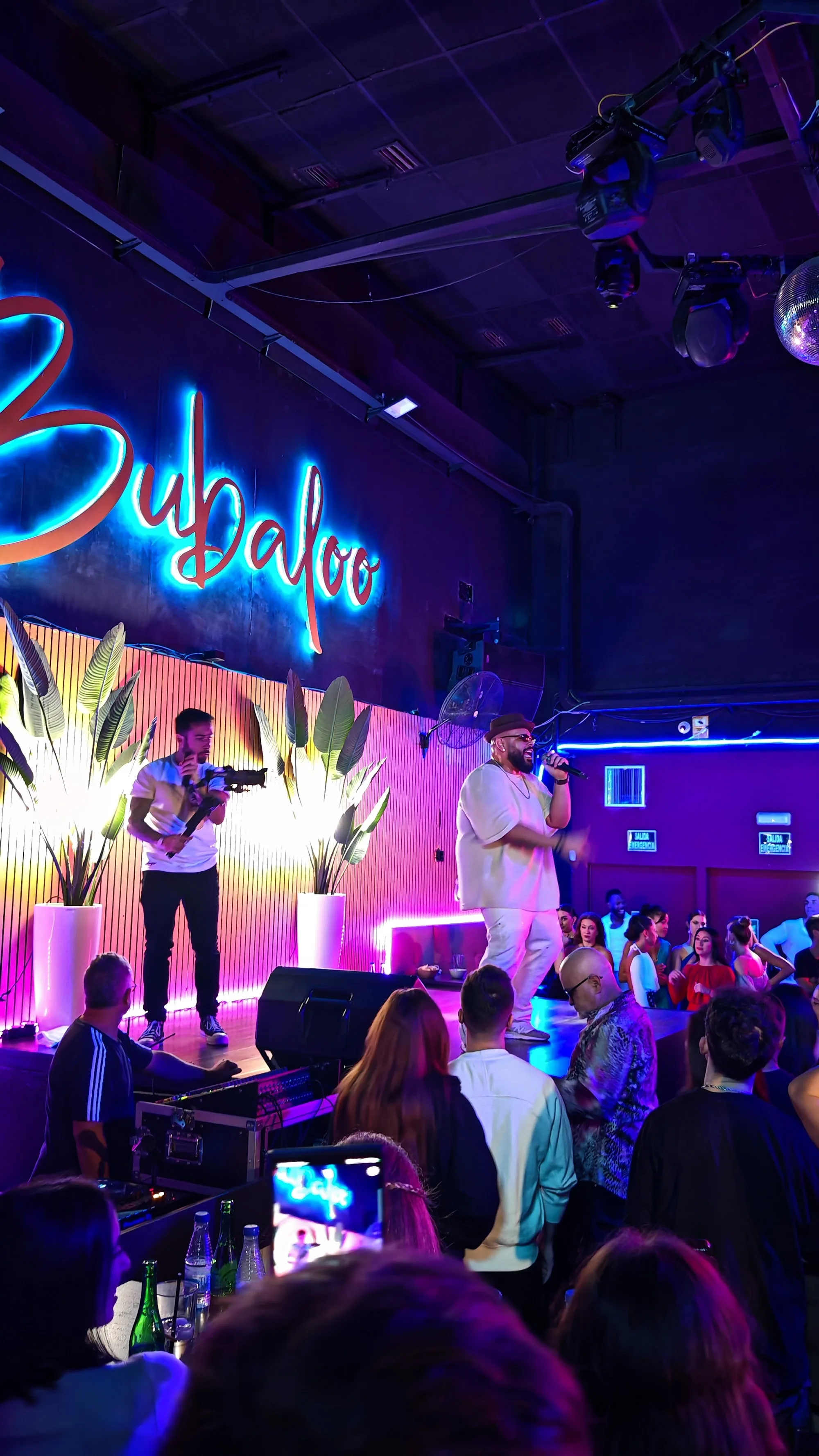 Live performance under the Bubaloo neon sign with crowd at Sala Bubaloo, Elche — salsa, bachata, kizomba venue in Elche