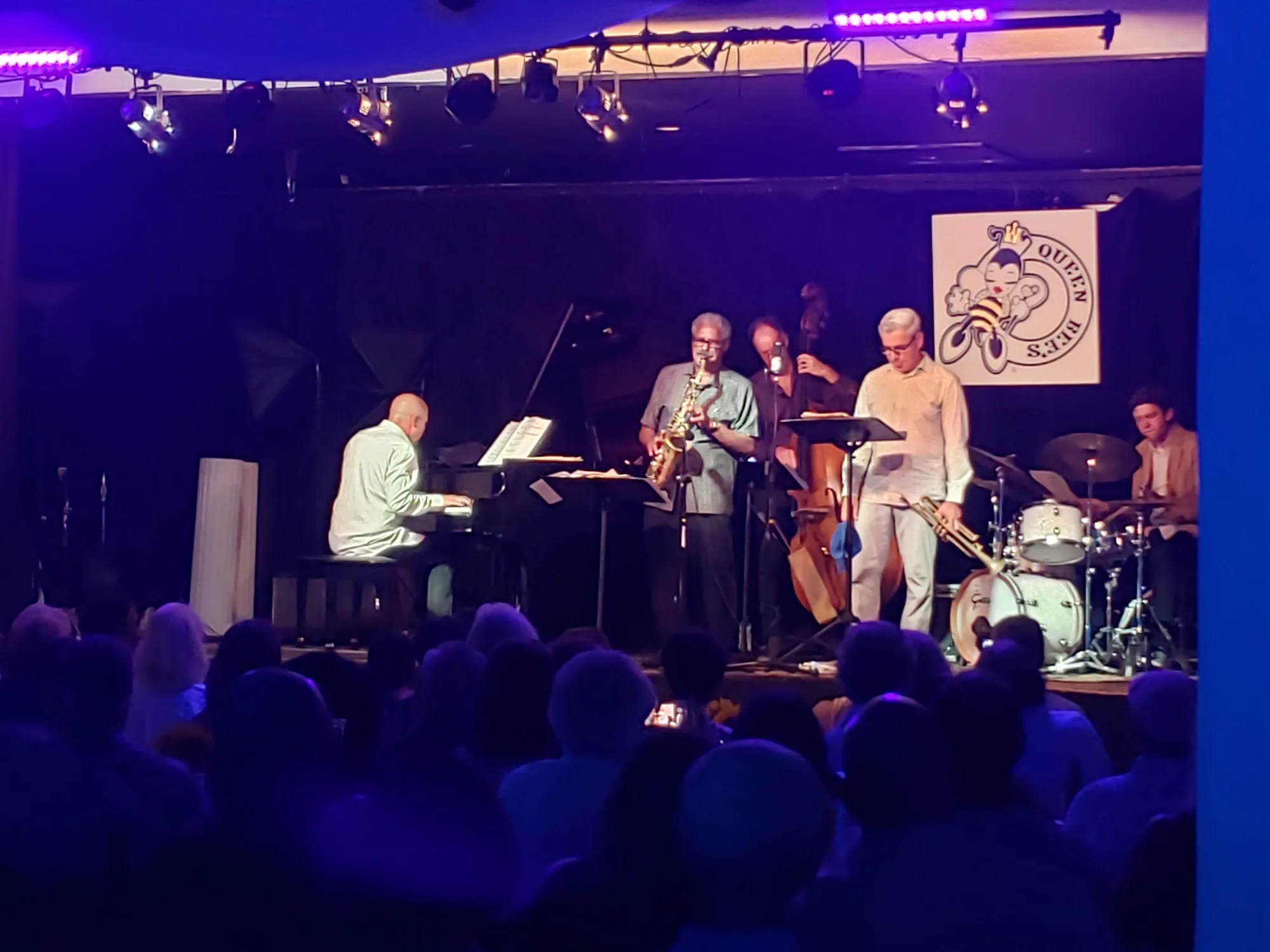 Live band performing on stage at Queen Bee's in San Diego with an audience