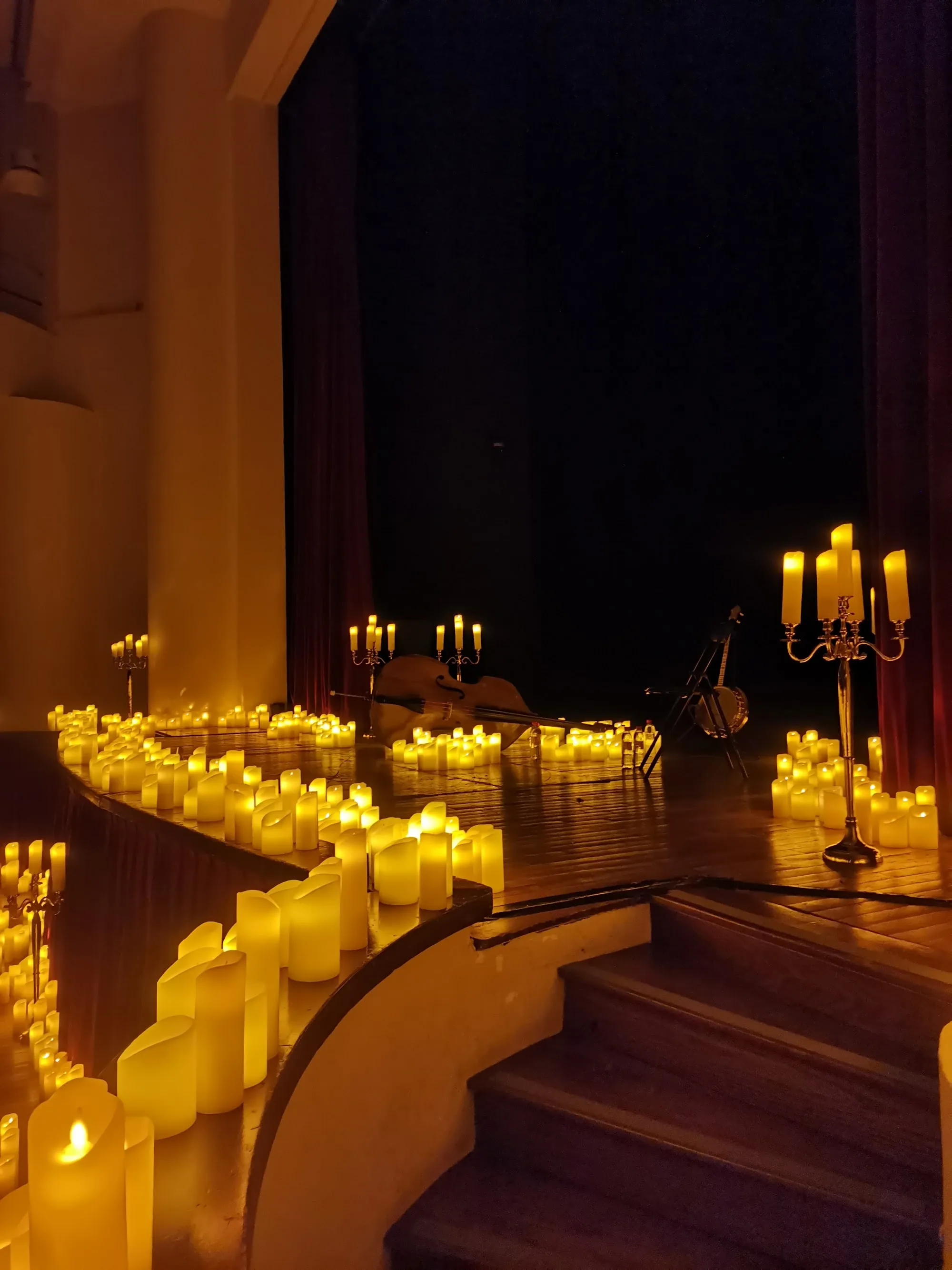 Candle-lit stage with instruments and warm atmospheric lighting at Salle Colonne, Paris dance and concert venue