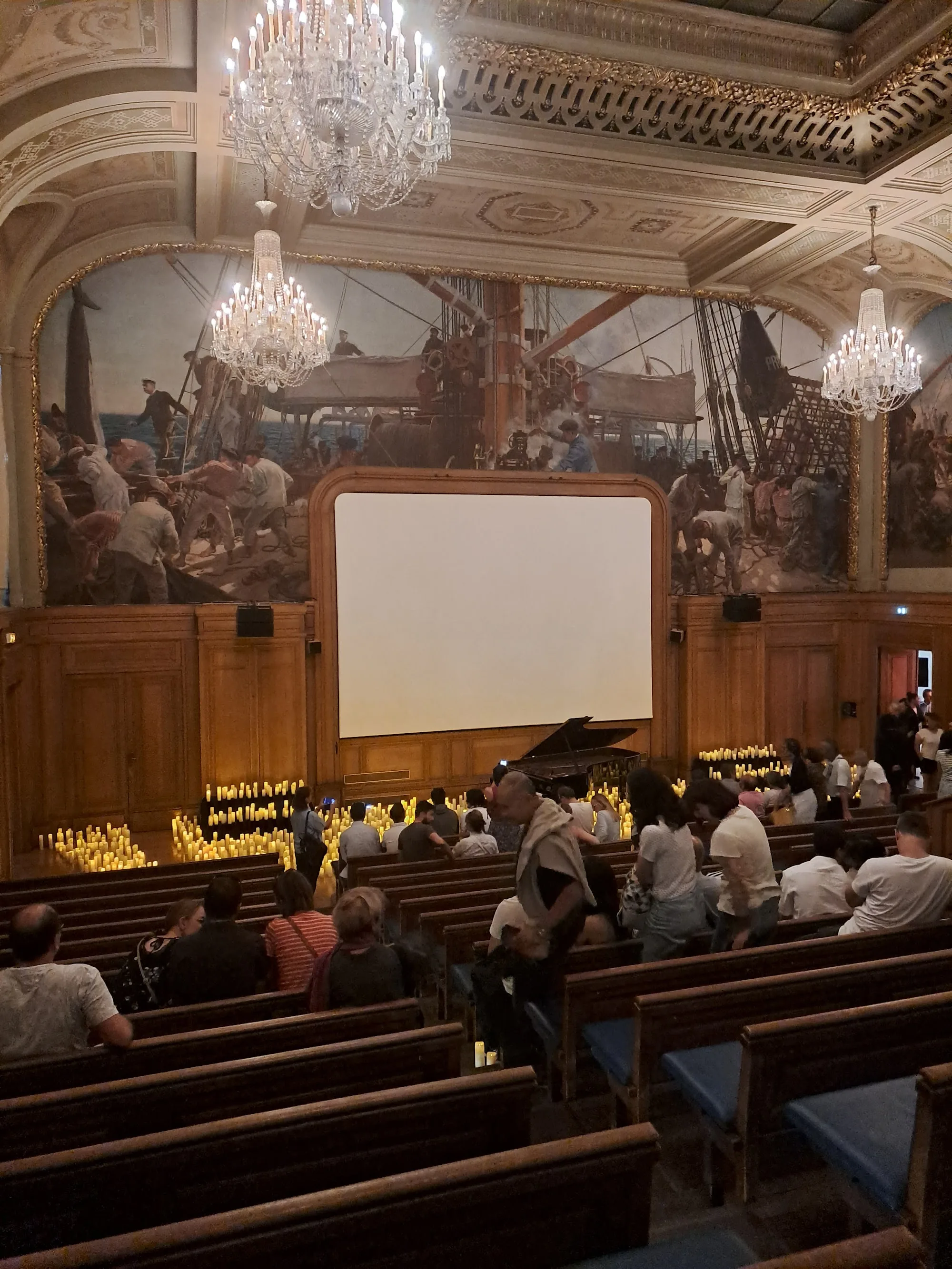 Ornate Salle Colonne auditorium interior with chandeliers, frescoes and seated audience in Paris