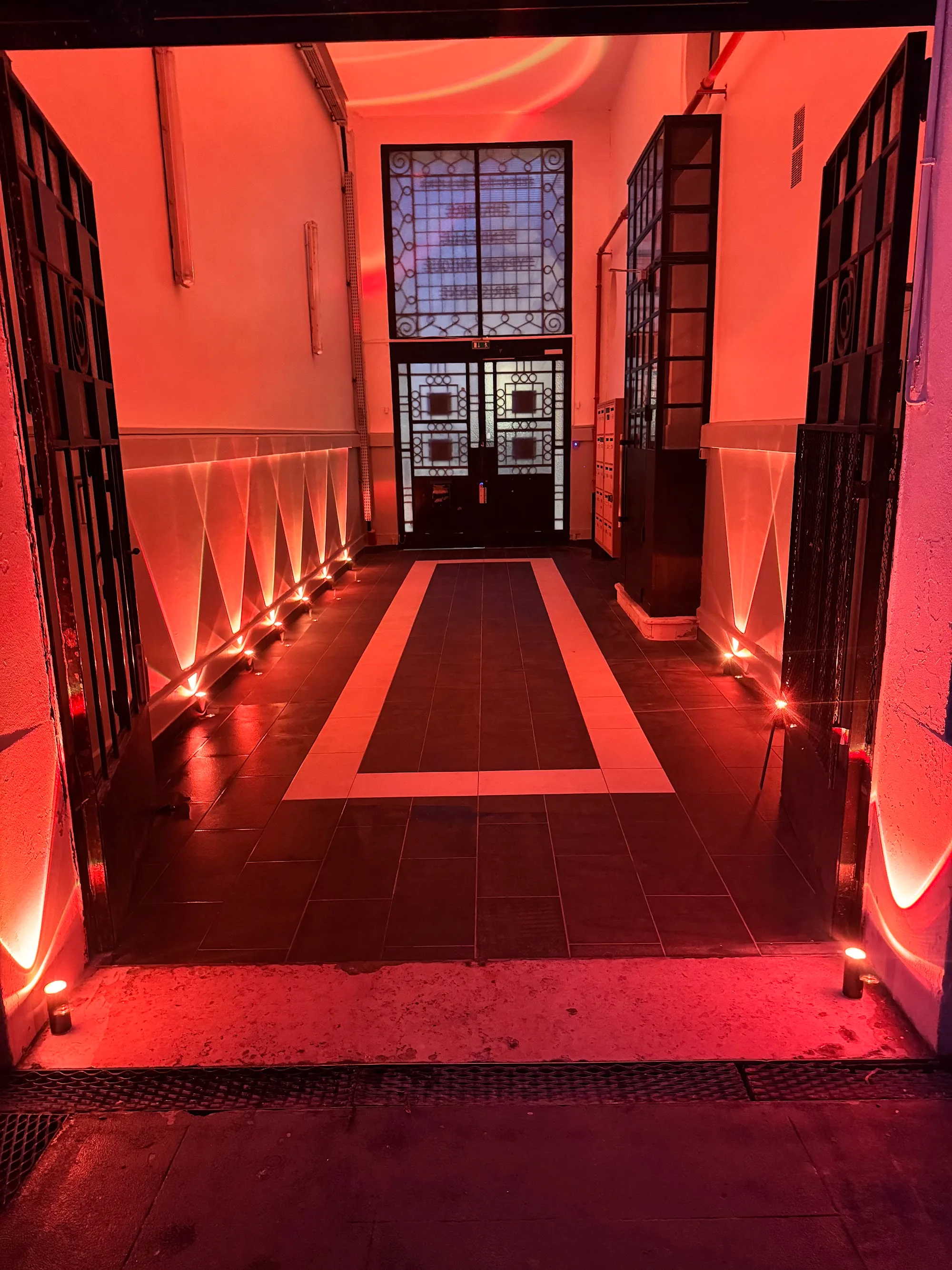 Illuminated entrance and red-lit corridor of Salle Colonne, Paris dance and event venue