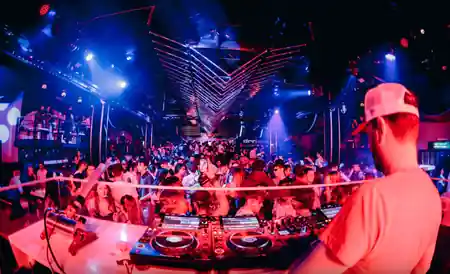 DJ playing to packed dance floor under V-shaped lighting rig at Discoteca Dorian Gray Verona — salsa, bachata, kizomba venue in Verona