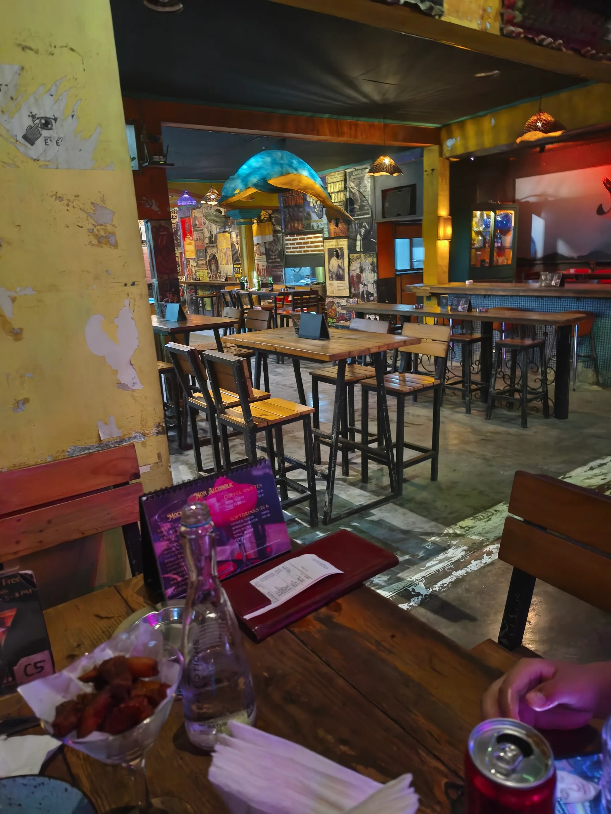 Eclectic interior with high bar tables and colorful decor at Bakfickan Bar in Sanur, Bali