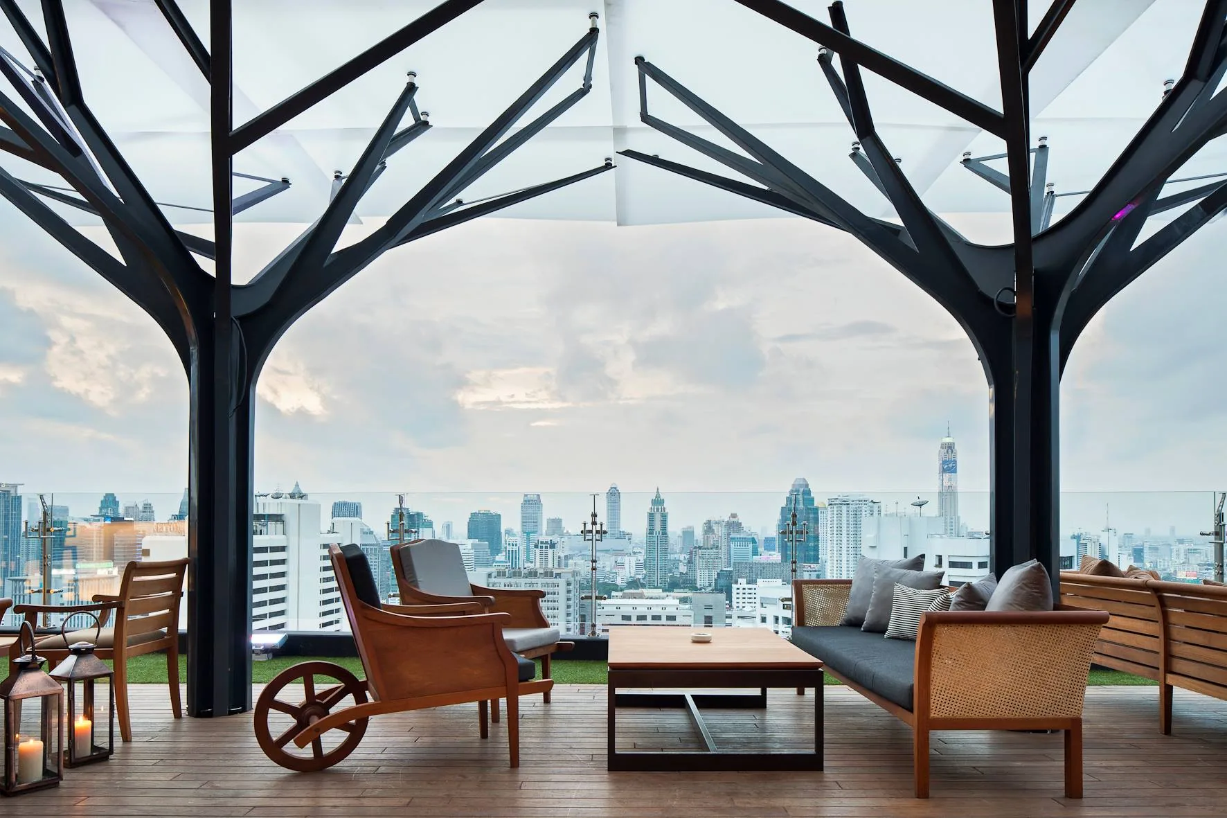 Rooftop lounge with tree columns and Bangkok skyline view at Above Eleven