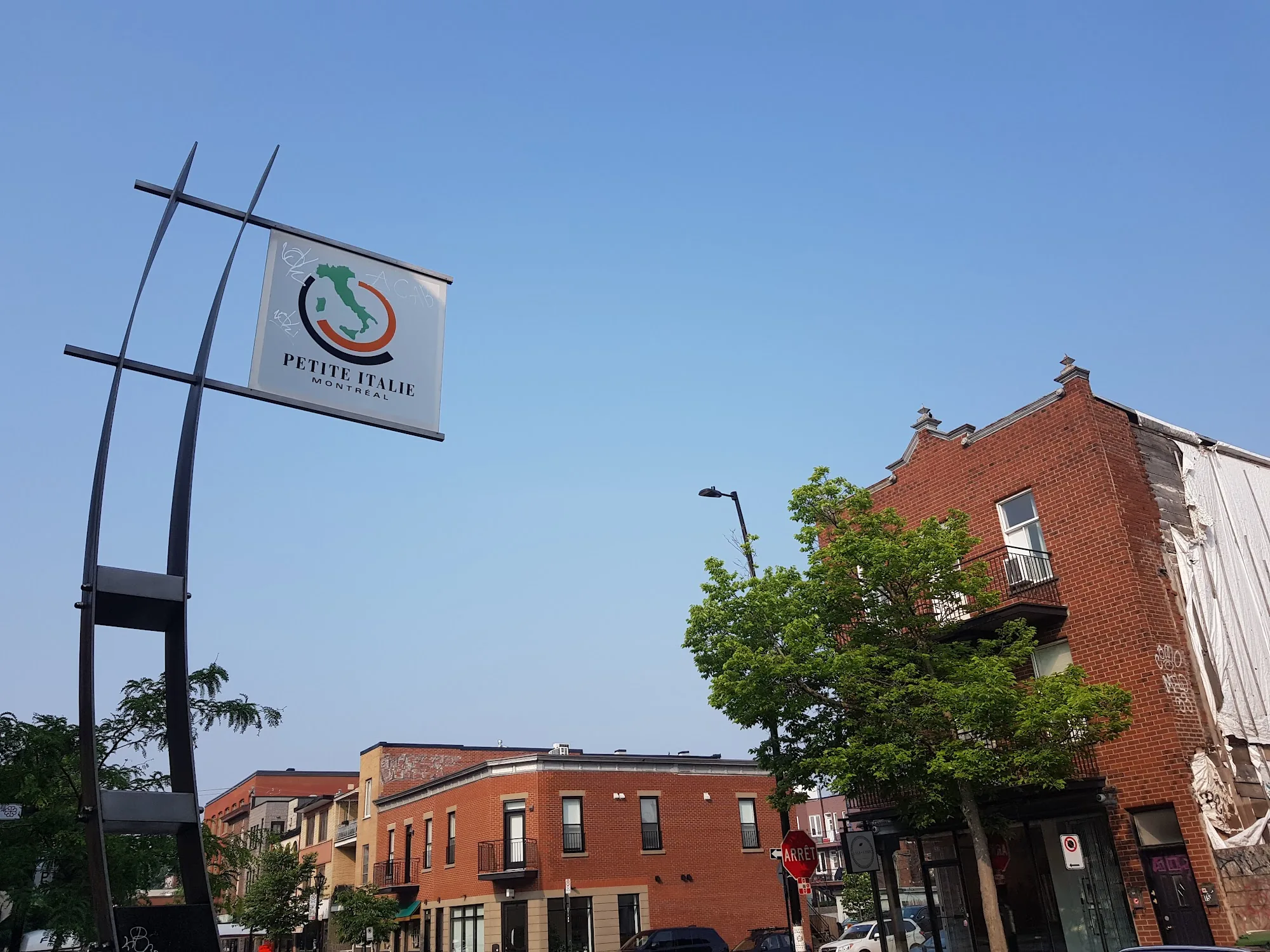 Park of Little Italy Montreal — Petite Italie neighbourhood sign with brick buildings in background