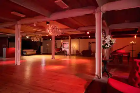 Large red-lit empty dance floor inside Tangoloft Berlin event space — salsa, bachata venue in Berlin