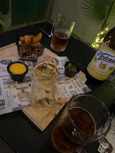 La Santa Beer and Food interior wall branding with customers seated in the background — salsa venue in San José del Cabo