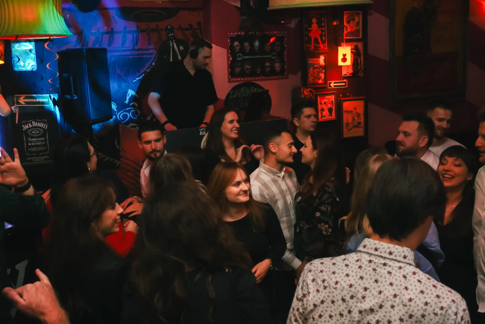 People dancing at Czarny Kot Klub Wroclaw with DJ booth and colorful wall art