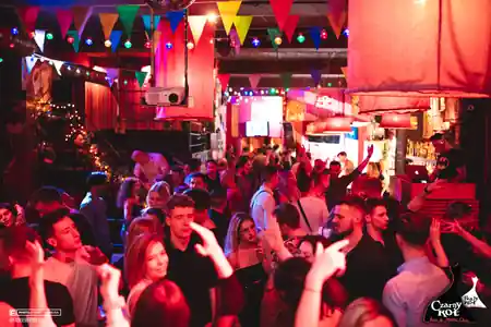 Crowded dance floor at Czarny Kot Klub Wroclaw with colorful bunting and party lights — salsa venue in Wroclaw