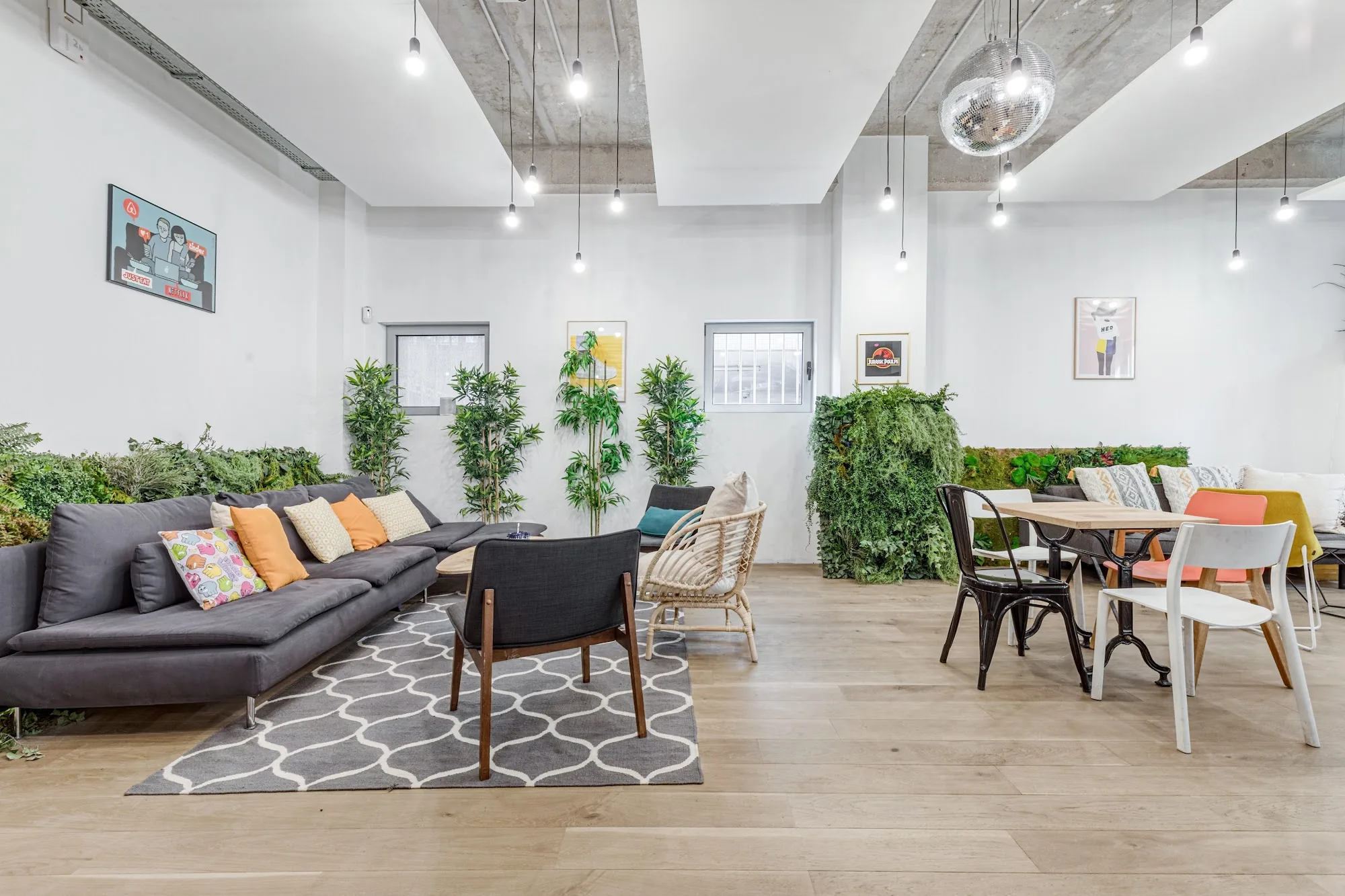 Bright lounge space at Le Café du Village with a disco ball, plants and coworking seating