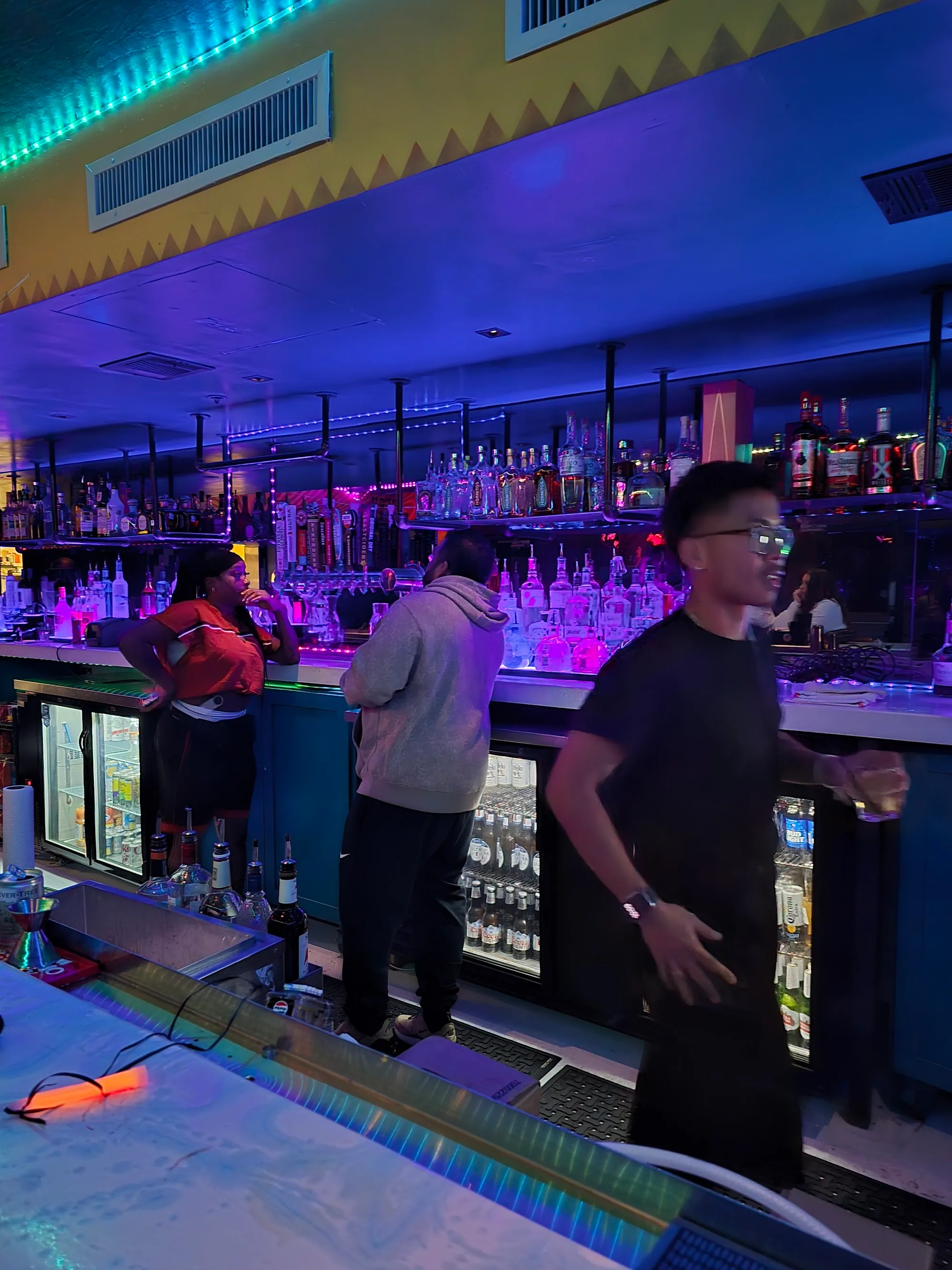 Full bar with neon lighting at Crazy Conchaz Austin Latin club