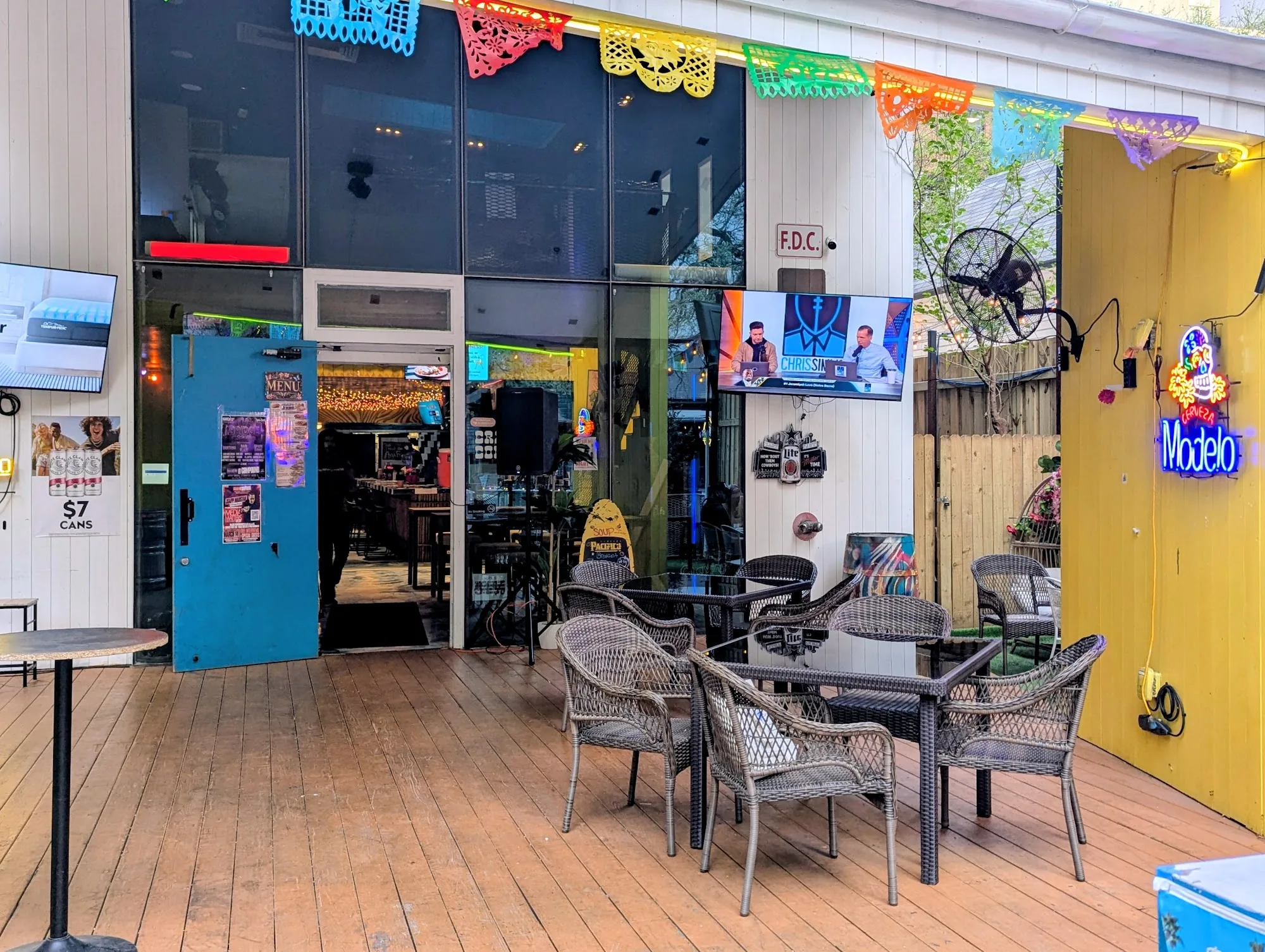 Outdoor patio with Mexican decorations and Modelo sign at Crazy Conchaz Austin