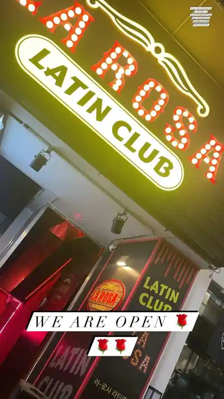 Multiple couples social dancing on a lit dance floor with stage lights at a Latin club in Seoul — salsa, bachata venue in Seoul