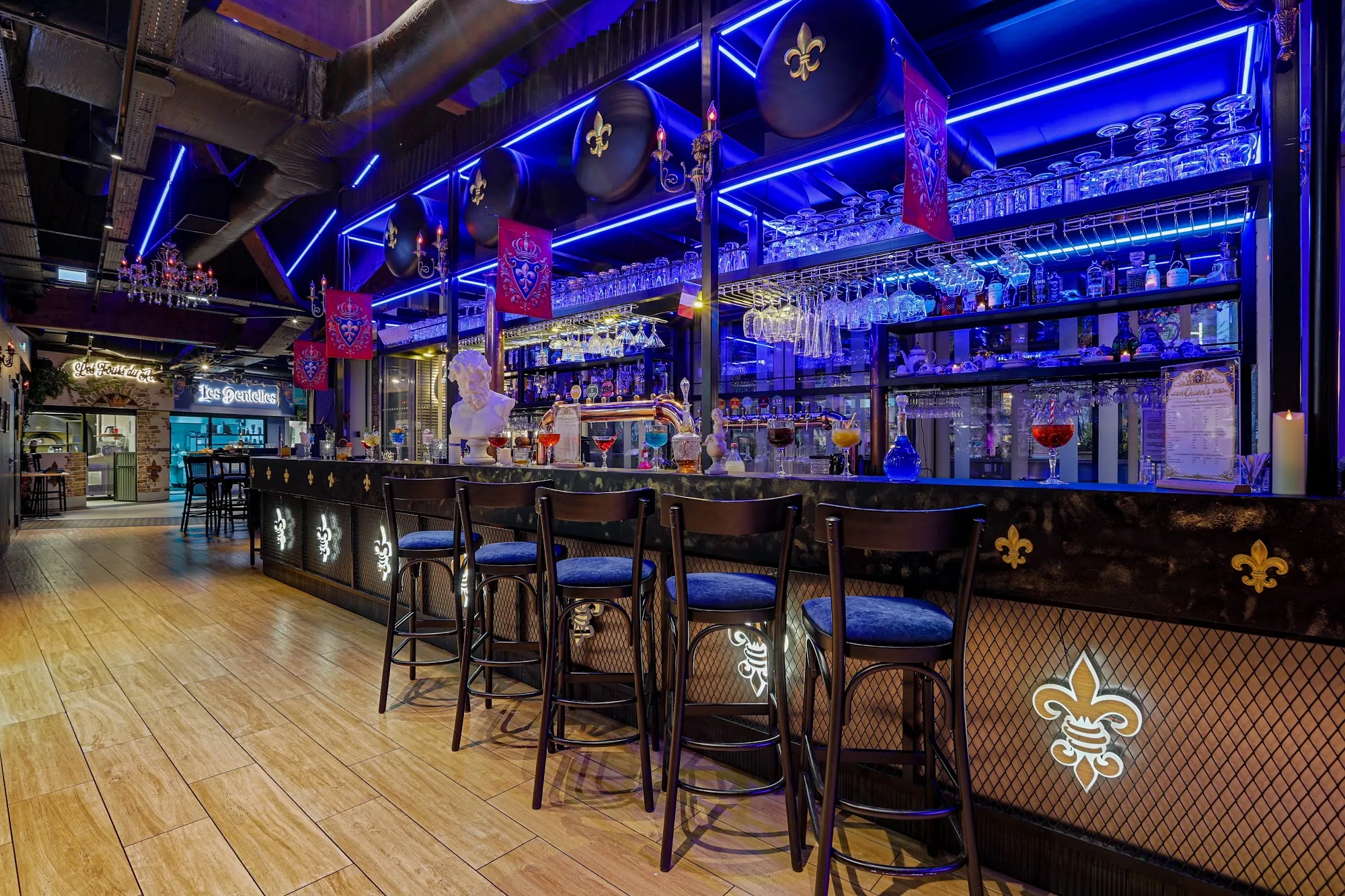 Owen's bar in Paris — main bar counter with blue neon lighting, stools and fleur-de-lis decor