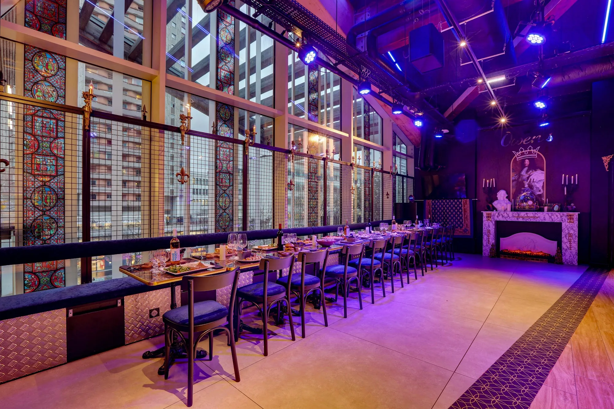 Owen's in Paris — long dining and dance floor space with stained-glass windows and purple stage lighting