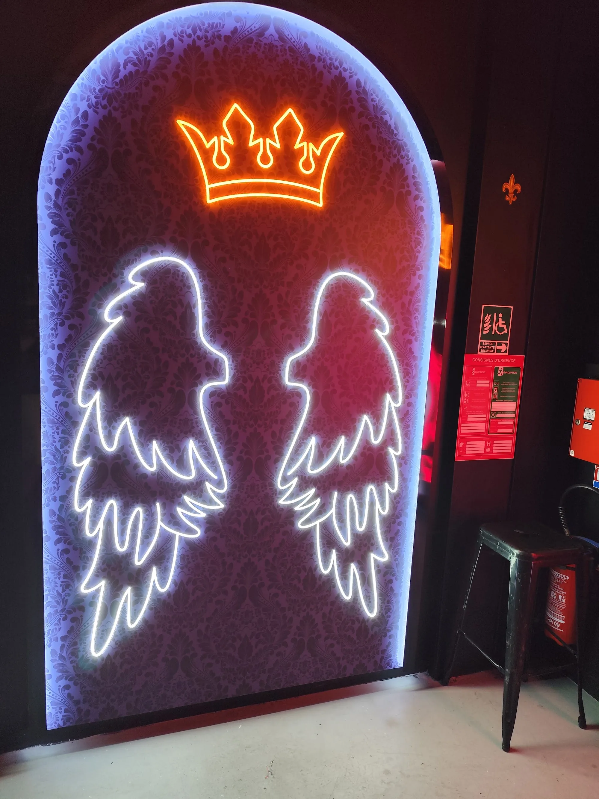 Owen's bar in Paris — neon angel wings and crown photo spot inside the lounge