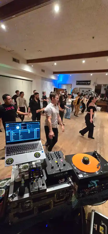 Social dancers on the wooden floor with DJ booth in foreground at The Beat in Berkeley — salsa venue in Berkeley