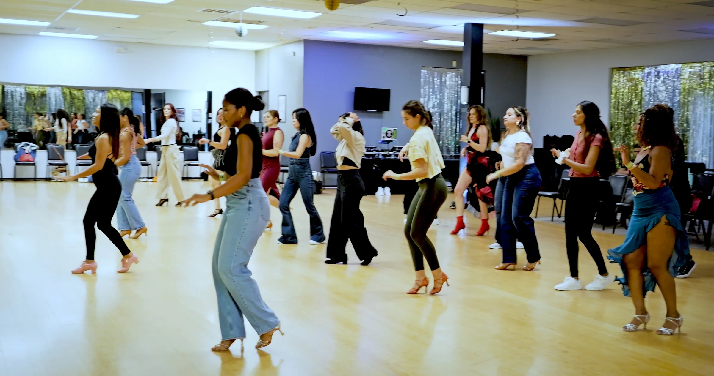 Group of dancers practicing Latin steps on the wooden floor at Austin Uptown Dance, Austin