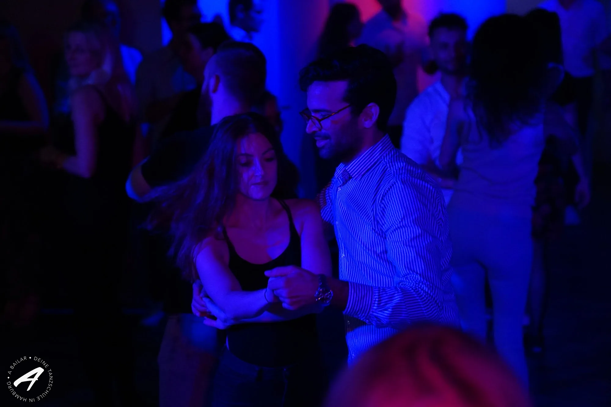 Couple dancing Bachata in close hold at A Bailar dance studio, Hamburg