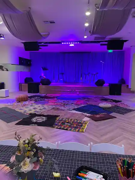 Dance hall interior at Little Light Venue with stage, blue curtain backdrop and dance floor with lighting rig — salsa venue in Los Angeles