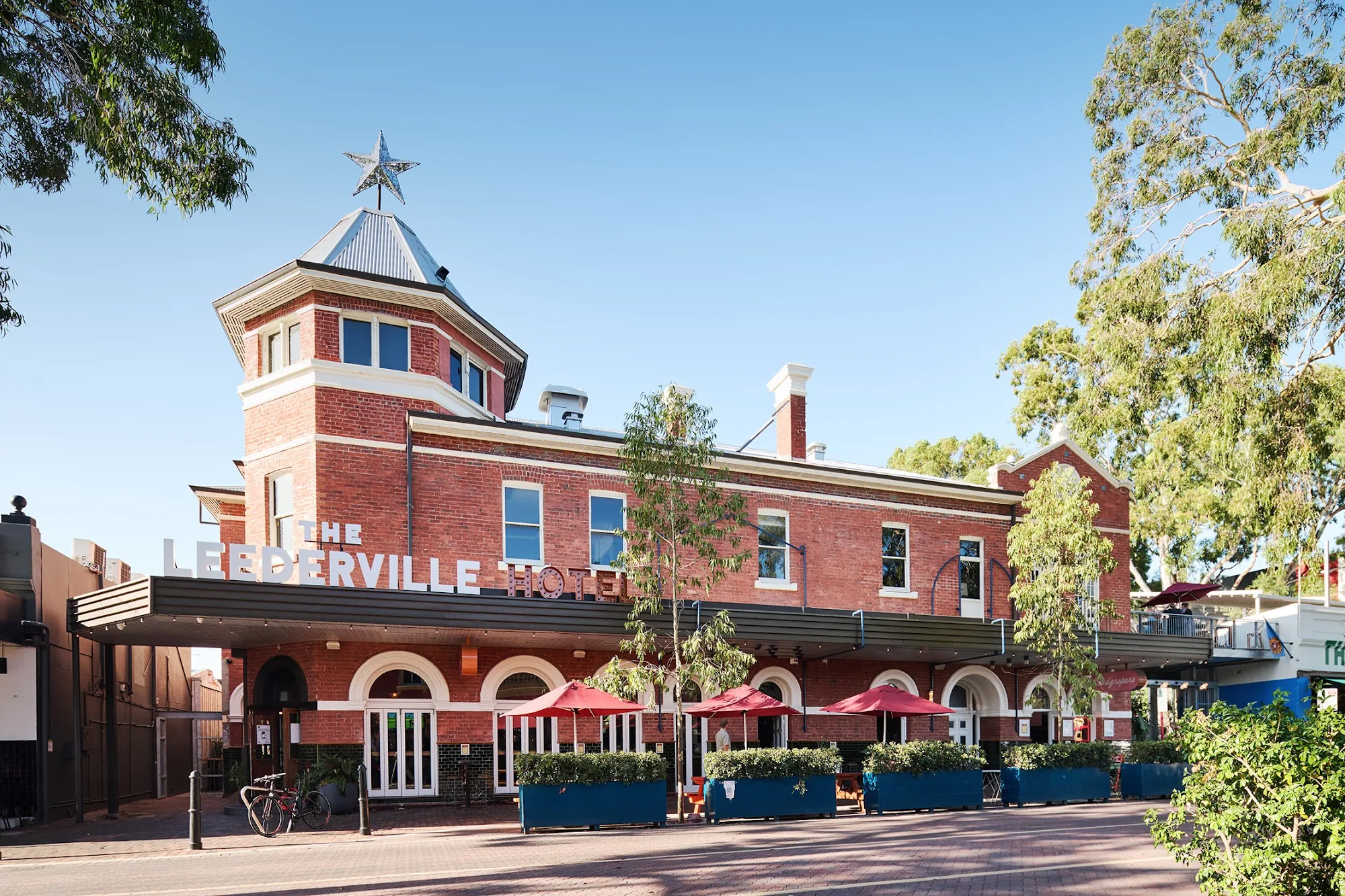 The Leederville Hotel exterior — a classic red-brick building with star atop the turret and outdoor seating