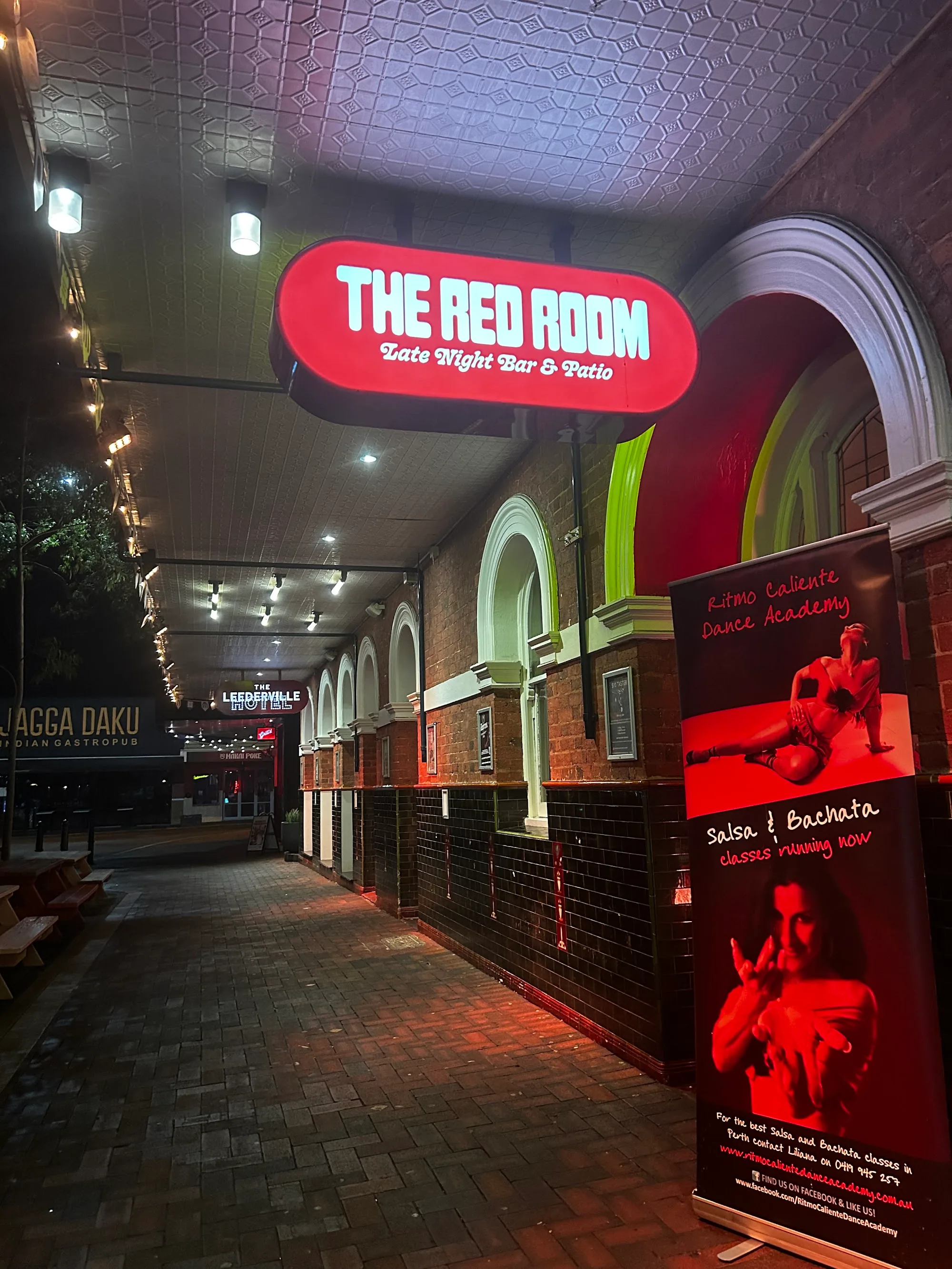 The Red Room Late Night Bar entrance at night with Ritmo Caliente Dance Academy Salsa and Bachata banner