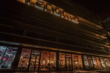 Exterior of Renoma building in Wroclaw at night with PeDeT visible through glass facade — salsa venue in Wroclaw