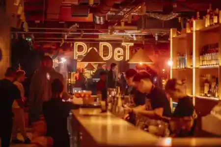 PeDeT bar area with neon sign and guests enjoying drinks at Renoma Wroclaw — salsa venue in Wroclaw