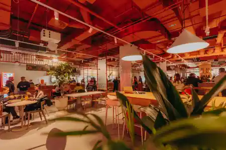 Modern interior of PeDeT food hall in Renoma Wroclaw with red industrial ceiling and diners — salsa venue in Wroclaw