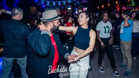 Couple dancing bachata on the crowded social floor at Bachata ConeXion in Melbourne