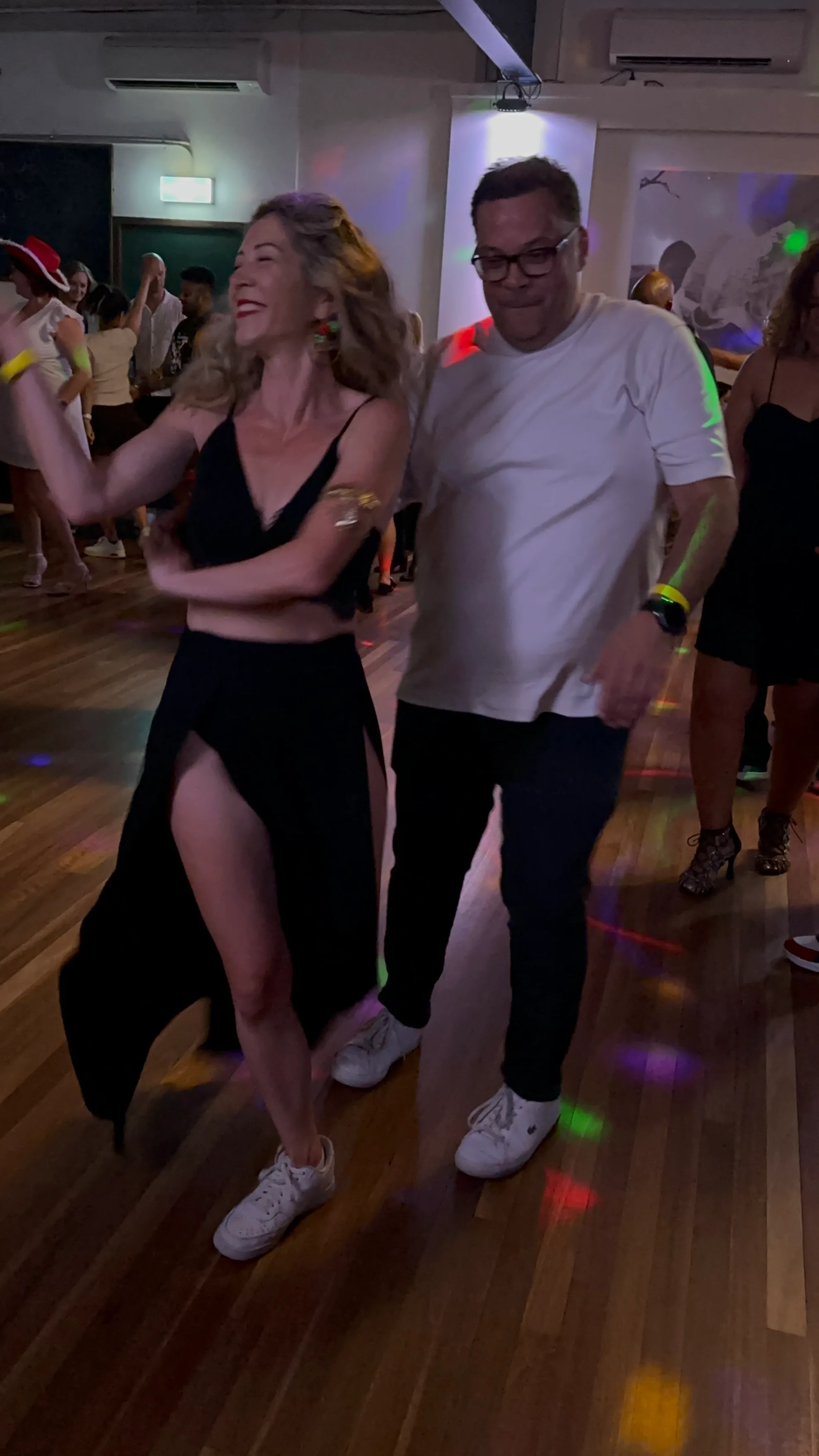 Dancers on the wooden dance floor with party lights at Bachata ConeXion in Melbourne