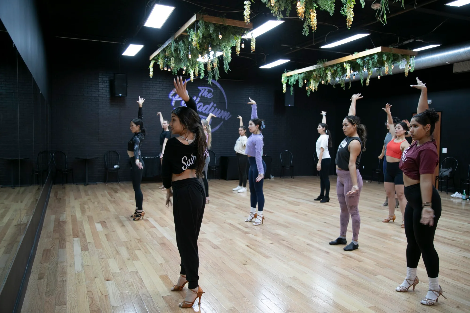 Latin dance class practicing on the wooden floor at The Palladium dance center, Houston