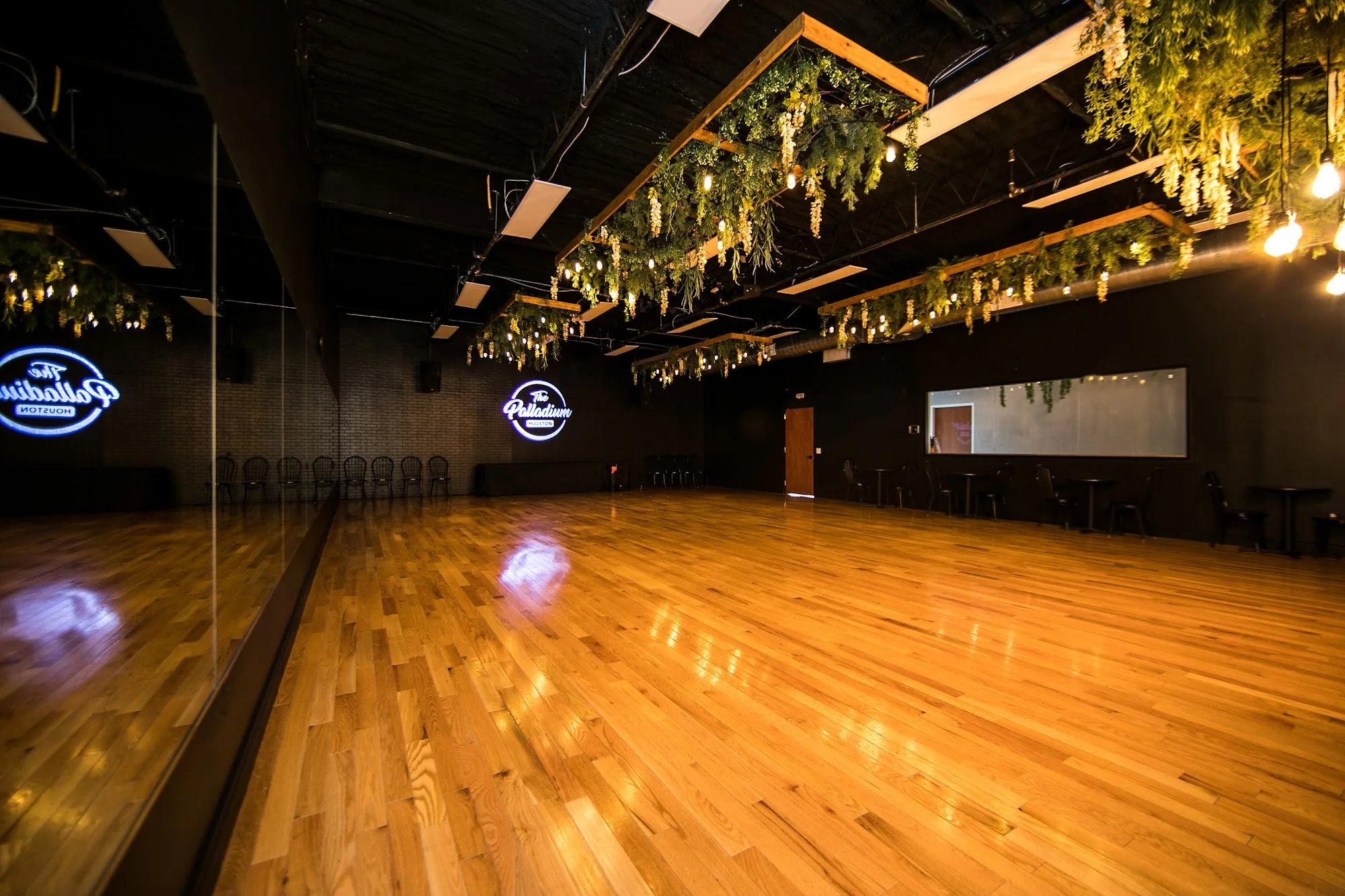 Mirrored dance floor with neon Palladium logo and hanging greenery, Houston