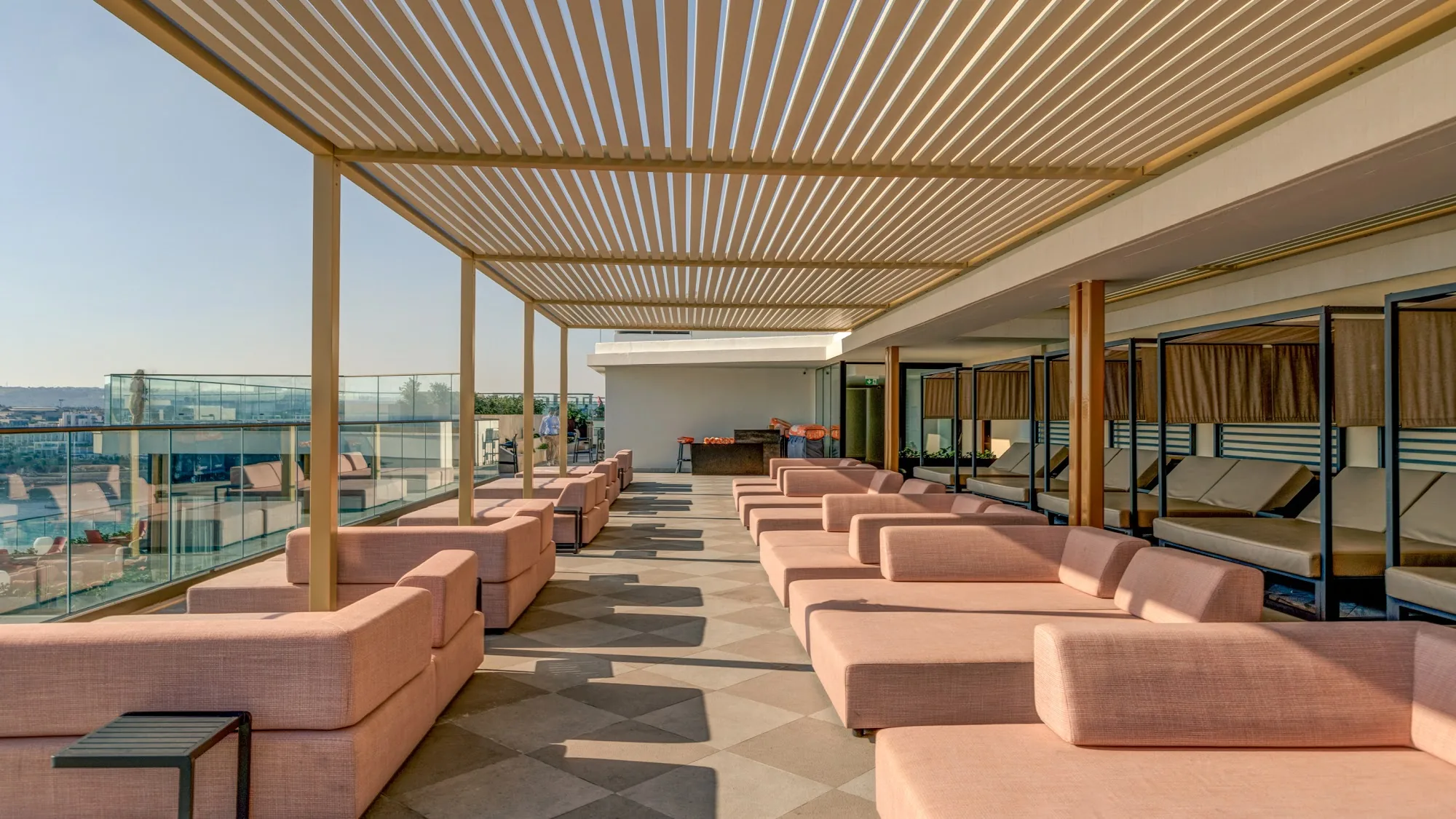 Rooftop terrace with pink sofas and sea view at AX Hotels Malta