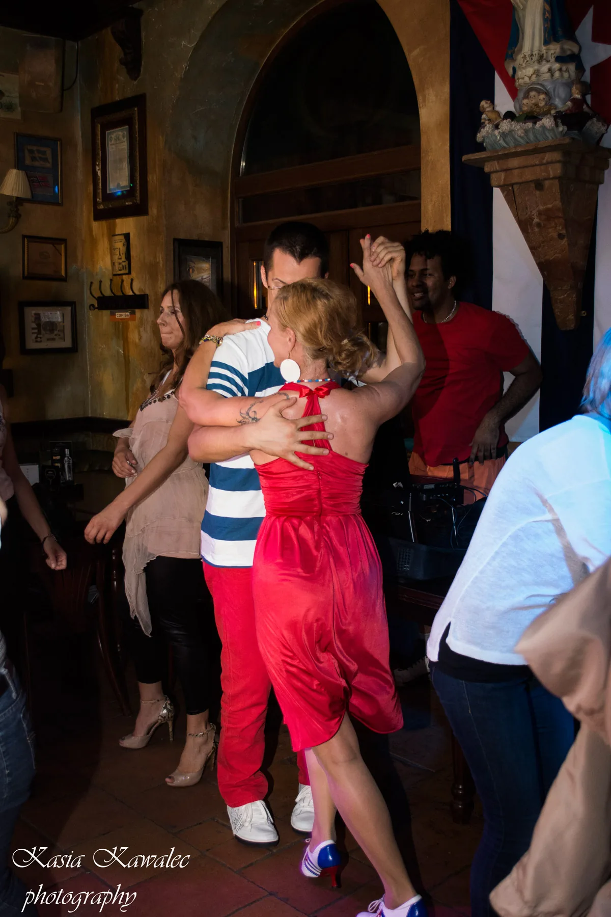 Couple dancing salsa at Casa de la Musica Wroclaw with Cuban flag in background