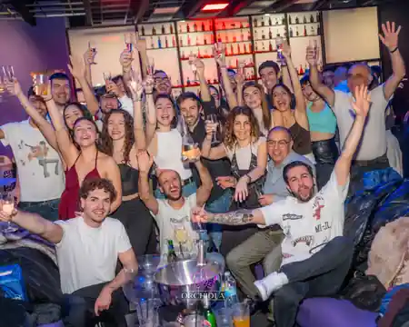 Crowd celebrating with raised glasses at Orchidea Club Latin night in Milan — bachata venue in Milan