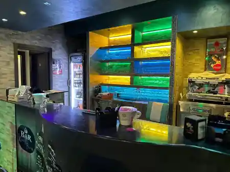 PERUNQUE bar counter with coloured LED shelving displaying glassware — kizomba venue in Rome