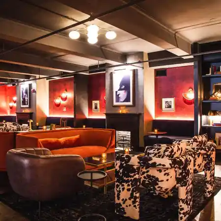 Moody lounge area with velvet sofas and art at 5th & Mad in New York — salsa venue in New York