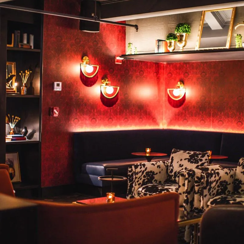 Red velvet lounge with banquette seating at 5th & Mad in New York