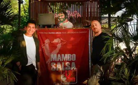 DJ booth with Mambo Salsa banner and guests at The Station, Paris
