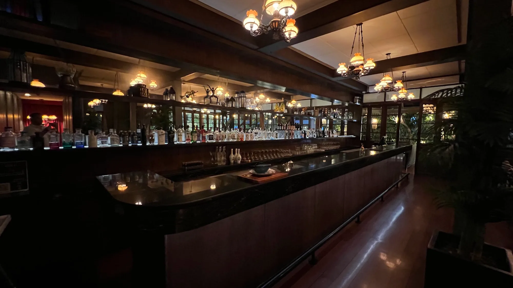Long wood bar with pendant lights at Hemingways Bangkok 2nd floor venue